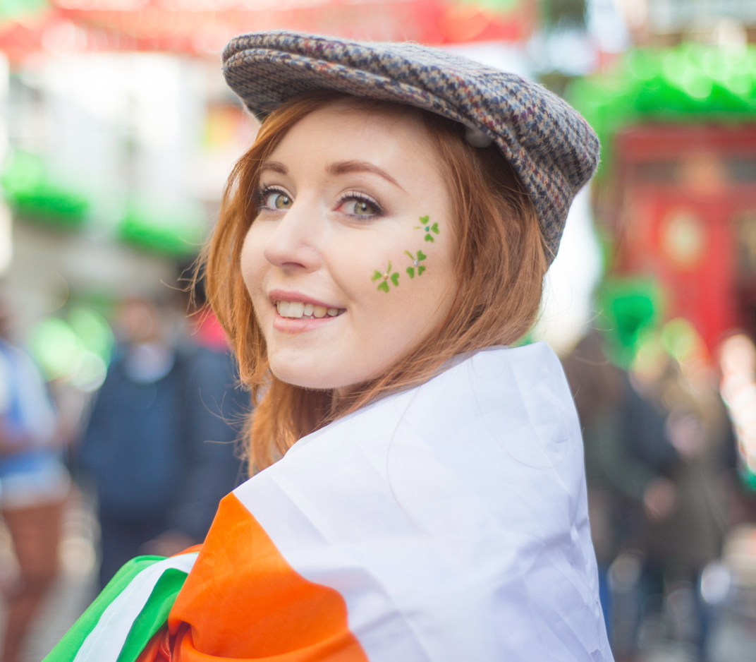 Girl at St. Patrick's Day parade wearing a hat with Irish flag colors